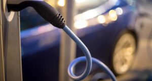 Electric car plugged into a charging cable at night