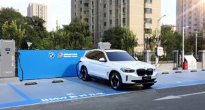 White BMW iX3 plugged in at a BMW and State Grid charging station in Beijing