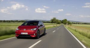Red Volkswagen ID.3 GTX electric hatchback driving on a country road
